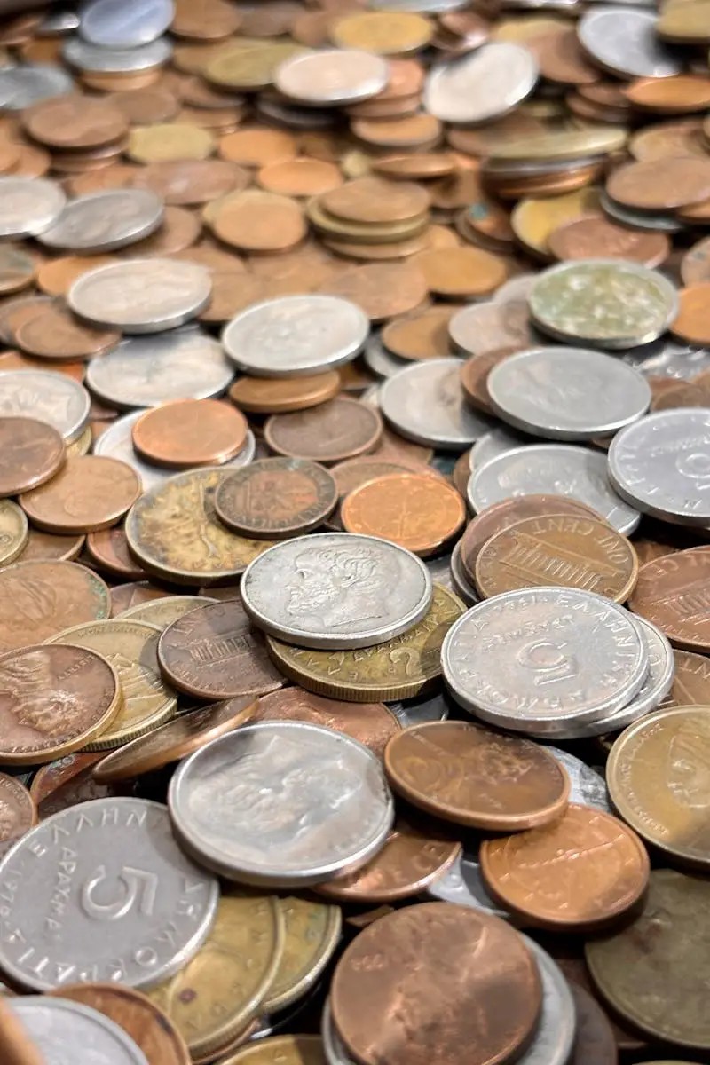 A collection of various international coins, silver, bronze, and copper, in a pile.